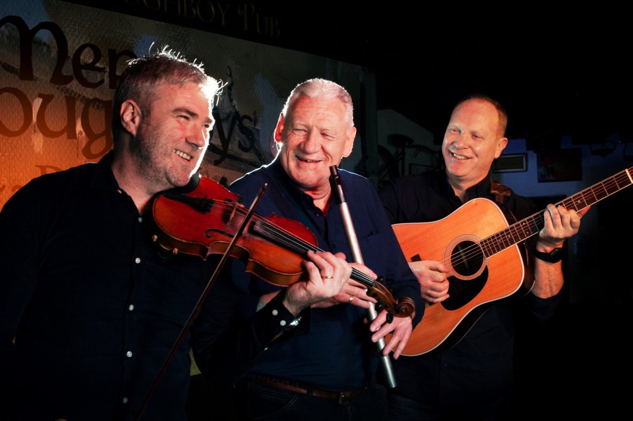 three men playing guitar, flute and violin