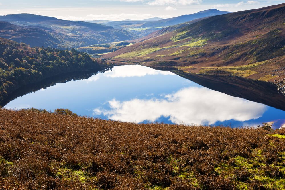 Mountain Side View of Glendalough lake surrounded by mountains on a sunny day 